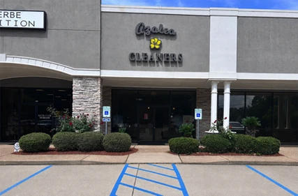 Storefront of Azalea Cleaners in a small shopping center, with landscaping and two accessible parking spaces in front.